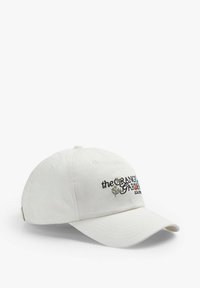 Gorra de algodón blanca con visera curvada, que presenta texto bordado multicolor y un diseño floral en la parte frontal. Correa ajustable en la parte trasera.
