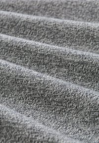 Textured fabric with a gray and white speckled pattern, showing soft, woven strands and a slight sheen across the surface.