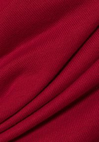 Roter Strickstoff mit glatter Textur, der Falten zeigt, die seine Dehnbarkeit und Fallbarkeit betonen. Einheitliche Farbe ohne Muster oder Akzente.