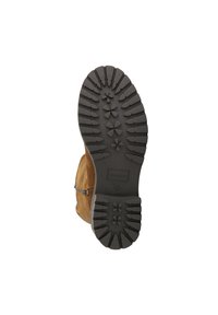 Semelle d'une botte en daim marron avec des motifs de bande de roulement profonds et le nom de la marque "Maruti" embossé sur la semelle en caoutchouc noir.