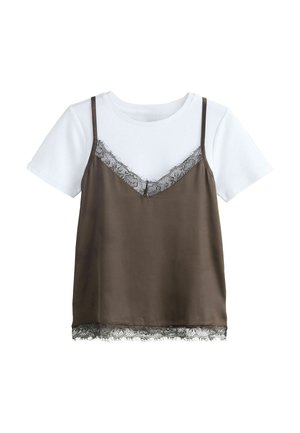 Fehér rövid ujjú póló, barna szatén kombinéval rétegezve, amelynek nyakkivágása és szegélye fekete csipkével díszített.
