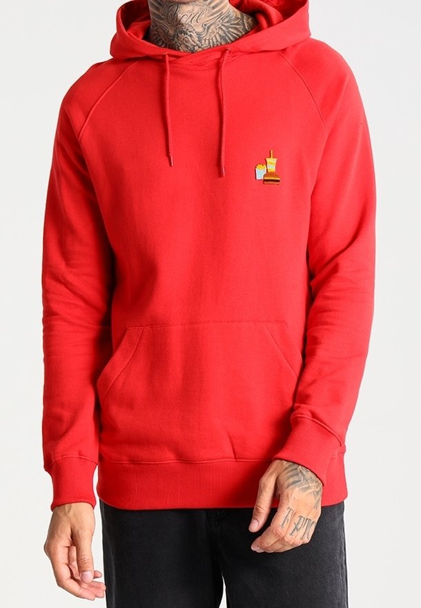 Hoodie rouge avec poche avant, ornée de petites icônes de fast-food brodées — frites, burger et boisson — porté par une personne tatouée.