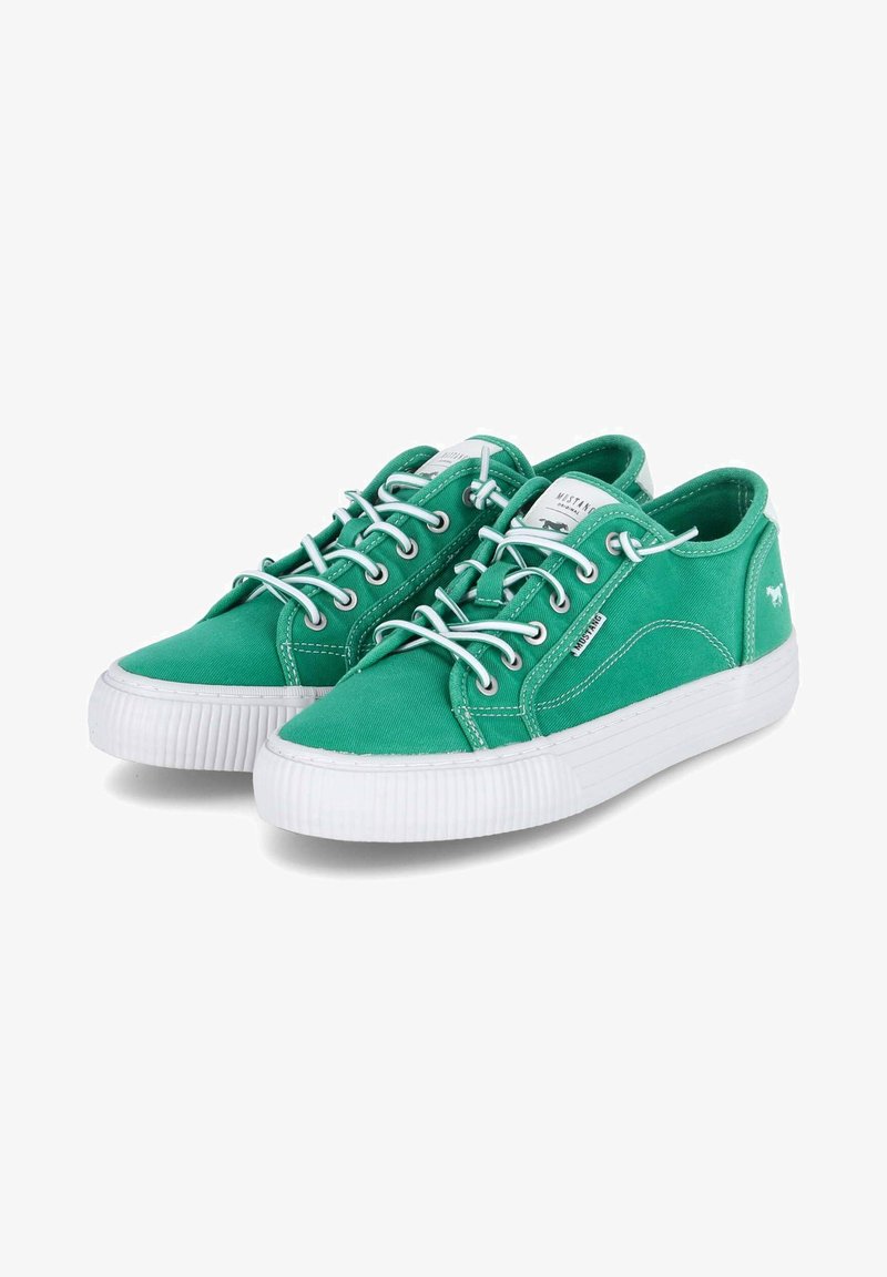 Grüne Canvas-Sneaker mit weißen Gummisohlen, abgerundetem Zehenbereich, Metallösen und weißen Schnürsenkeln. Einfaches Design mit seitlicher Steppnaht.
