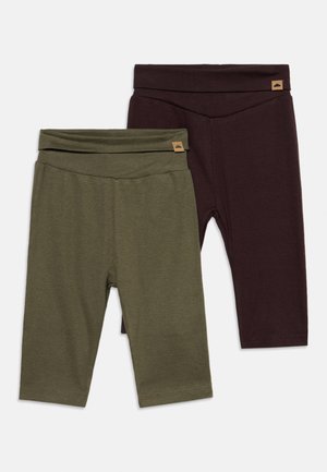To parfoldede baby leggings, en olivengrøn og en mørkebrun, hver med et lille påsyet mærke på taljen.
