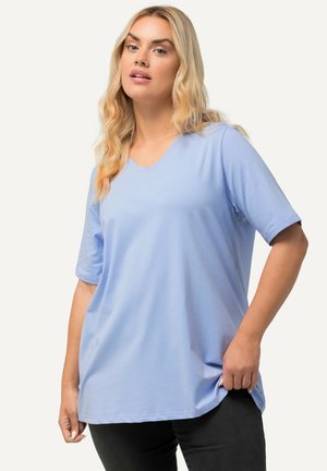 T-shirt bleu clair en V fabriqué à partir d'un tissu doux, avec des manches courtes et une coupe décontractée, porté avec un pantalon noir.