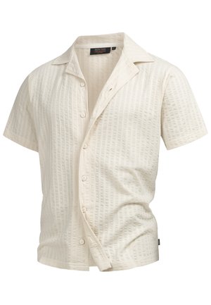 Short-sleeve shirt in cream with a textured, ribbed pattern. Features a collar and front buttons, crafted from lightweight fabric.