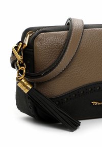 Braune und schwarze Lederhandtasche mit goldfarbenen Details, Reißverschluss, Quastenakzent und durchbrochenem Designdetail entlang der oberen Kante.