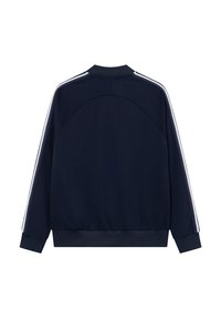 Σακάκι στίβου ναυτικού τύπου από μαλακό ύφασμα, με λευκές ρίγες στις πλευρές, ψηλό γιακά και ραμμένα μανίκια και στρίφωμα. Εμφανίζεται η πίσω όψη.