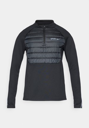 Black long-sleeve pullover with zippered collar; features quilted puffer chest panel; “SPURS” and Nike logos in light blue on the front.