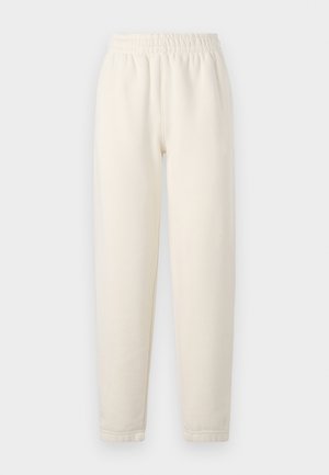 Calças de fato em cor creme feitas de um tecido suave. Apresentam uma cintura elástica e um design com pernas afuniladas, com detalhes de costura subtis.