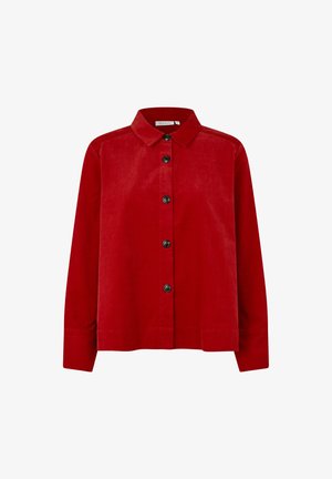 Czerwona koszula z korduroyu z kołnierzykiem, zapinana na guziki z długimi rękawami. Posiada czarne guziki i prosty dół.