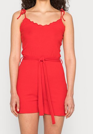 Czerwona prążkowana sukienka z dekoltem w serek, falbanianymi krawędziami, regulowanymi wiązanymi ramiączkami oraz dopasowanym paskiem w talii. Gładka faktura, dopasowana sylwetka.