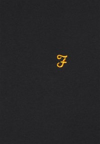 Tessuto nero con una struttura liscia. Presenta una piccola lettera "F" ricamata di colore giallo al centro in basso. Design semplice e minimalista.