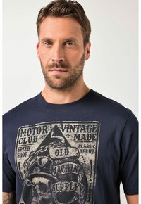 Navyblauw t-shirt met een verweerde grafische print van een schedel, kettingen en textelementen in beige en zwart. Klassieke ronde hals.