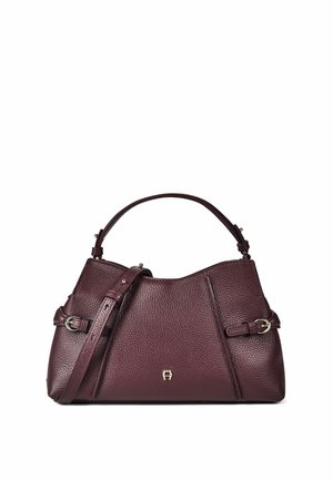 Bolso de mano de cuero texturizado de color púrpura oscuro con asa superior, correa de hombro ajustable, hebillas plateadas y pequeño logo metálico en el centro delantero.