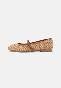 Zapato plano tejido con un patrón de zigzag en tonos tierra, con una correa de tobillo marrón en contraste y un tacón cuadrado bajo.