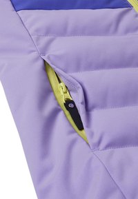 Gefütterte Jacke mit einer lavendelfarbenen Außenhaut, einem kontrastierenden tealfarbenen oberen Abschnitt und einem limettengrünen Reißverschluss mit einem schwarzen Ziehband.