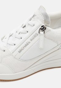 Weißer Sneaker aus strukturiertem Leder mit Mesh-Elementen und silberner Hardware. Verfügt über eine Schnürung und ein Logodetail an der Seite.