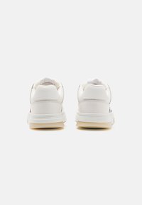 Sneaker bianchi con una parte superiore in pelle testurizzata, suola in gomma e accenti colorati sui lati. Punta arrotondata con colletto imbottito.