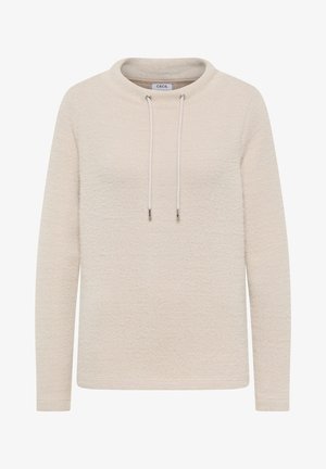 Sudadera beige claro con un patrón texturizado, escote redondeado y detalles de cordón. Mangas largas con puños sutiles. Etiqueta de la marca visible.
