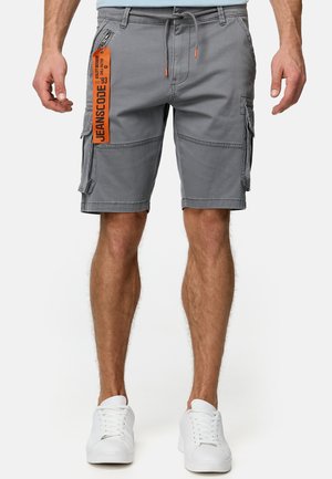 Shorts cargo gris en mélange de coton, dotés de poches, d'une taille à cordon de serrage avec des accents orange et d'une étiquette de marque attachée.