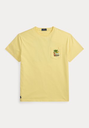 Κίτρινο κοντομάνικο t-shirt με στρογγυλή λαιμόκοψη και τσέπη στο στήθος που διαθέτει τροπικό σχέδιο με φοινικόδεντρο, ήλιο, λουλούδια και τη λέξη "Polo".