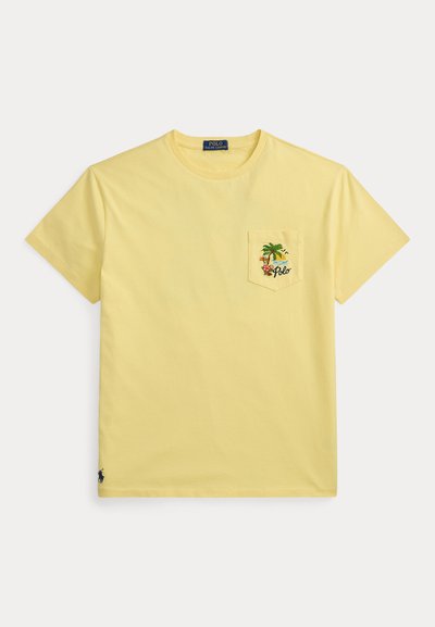 Κίτρινο κοντομάνικο t-shirt με στρογγυλή λαιμόκοψη και τσέπη στο στήθος που διαθέτει τροπικό σχέδιο με φοινικόδεντρο, ήλιο, λουλούδια και τη λέξη "Polo".