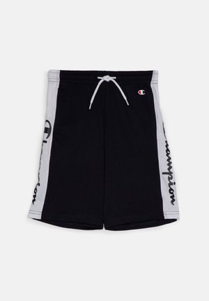Pantalones cortos deportivos negros con paneles laterales blancos, cordón blanco y texto y emblema "Champion" en el lado izquierdo.