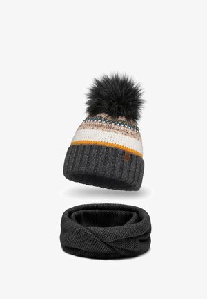 Gorro de punto con un pom-pom de pelaje sintético negro, rayas beige y grises, y un acento naranja. Bufanda infinita negra de punto texturizado abajo.