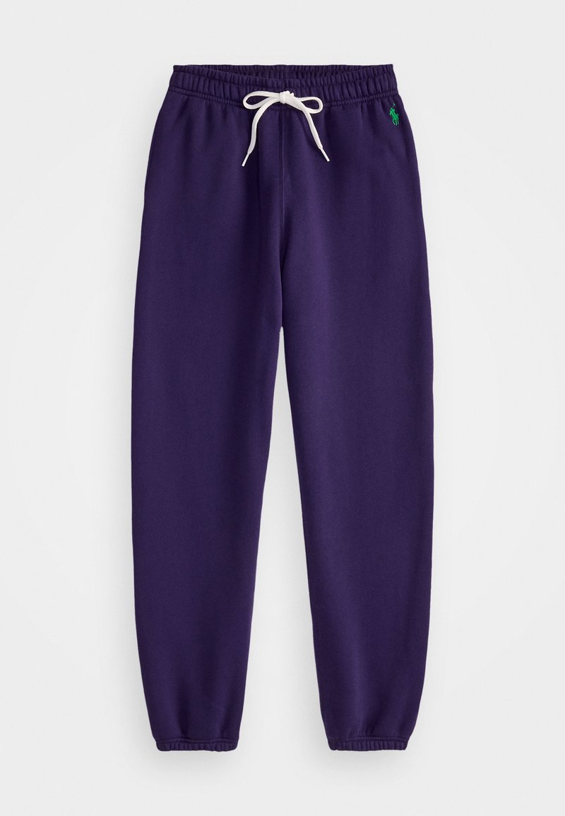 Paarse trainingsbroek van zacht materiaal, met een elastische tailleband, witte koordsluiting en ribbelmanchetten. Klein groen logo vlakbij de taille.