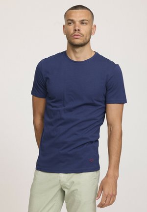 T-shirt à manches courtes bleu marine en coton, avec un col rond et un petit logo rouge brodé à l'ourlet. Texture lisse et design ajusté.