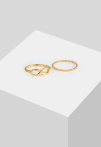 Inele din aur cu un design ce reprezintă simbolul infinitului și un band cu textură învârtoșată. Ambele inele au o finisare lustruită și un stil minimalist.