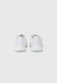 Witte sportieve schoenen met een gestructureerde bovenkant, contrasterende witte accenten aan de zijkant en een flexibele lichtblauwe zool. Ronde, gevoerde hakontwerp.