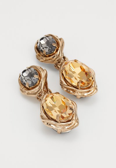 Goldfarbene Ohrringe mit großen ovalen Bernsteinen und kleineren ovalen rauchgrauen facettierten Edelsteinen in kunstvollen Krappenfassungen.