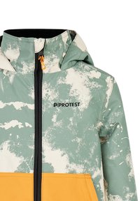 Groene en crèmekleurige jas met een oranje onderpaneel. Heeft een hoge kraag, een rits aan de voorkant en een logo op de borst.