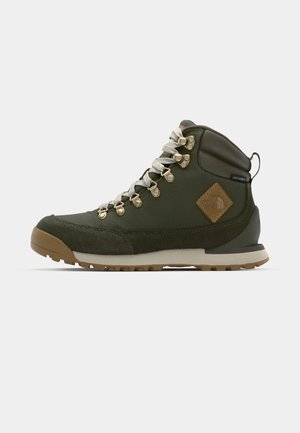 Green hiking boots featuring a suede and synthetic upper, gold eyelets, and a rubber outsole with a textured finish for traction.