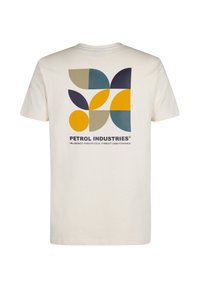 Krémové tričko s geometrickým potiskem na zadní straně v námořnické modři, hořčicově žluté, tyrkysové a béžové barvě s nápisem "PETROL INDUSTRIES" pod ním.