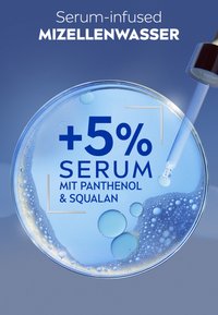 Serum-infused micellar water in a clear container, featuring bubbles and droplets, with blue liquid and bold text highlighting active ingredients.