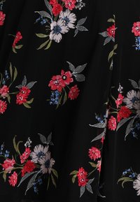 Černá textilie s barevnou květinovou výšivkou v červené, růžové a modré. Obsahuje podrobné listy a texturovaný povrch.