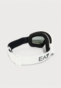 Λευκά γυαλιά σκι με μαύρο αφρώδες υλικό γύρω από τους φακούς και ρυθμιζόμενο λουράκι σε λευκό χρώμα με την επιγραφή "EA7".