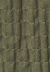 Vaddad tyg med horisontella stygn som skapar ett rutmönster i olivgrönt strukturerat material.