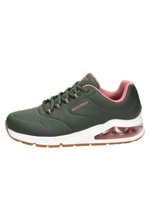 Ciemnozielony sneaker Skechers z różowymi akcentami, białą podeszwą, poduszką powietrzną w pięcie, wiązaniem na sznurowadła oraz brązową, bieżnikowaną podeszwą zewnętrzną.