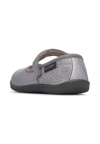 Scarpa grigia con punta in pelle liscia e tacco in tessuto metallico texturizzato. Presenta una fascia in Velcro e una suola in gomma nera.