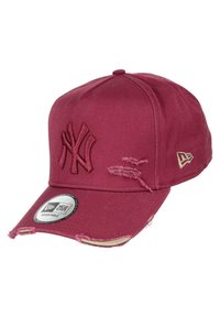 Red cotton baseball cap with embroidered NY logo, distressed detailing on the brim, and an adjustable strap at the back.