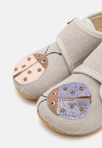 Szare buty materiałowe z wzorami biedronek na czubkach, z różowymi i fioletowymi akcentami, teksturowanymi cholewkami i zapięciem na rzepy.