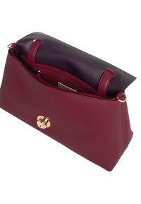 Bordeaux lederen handtas met een gladde textuur, gouden ronde hardware en een donkerpaarse voering. Beschikt over een ritsvak en een ruime interieur.