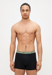 Boxers noirs avec une ceinture verte arborant le logo "BJÖRN BORG", en tissu lisse, au design ajusté et avec une longueur de jambe standard.