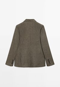 Ruskea teksturoitu bleiseri, joka on muotoilultaan istuva, takana yksittäinen halkio, kauluksessa lovet ja jokaisessa hihassa viisi nappia.