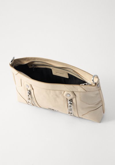 Sac à main en cuir beige avec une texture lisse, doté d'une fermeture éclair, de quincaillerie en argent et d'un intérieur spacieux. Les accents comprennent des poches avant.