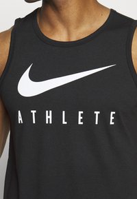 Czarny bezrękawnik sportowy z dużym białym logo Nike oraz słowem "ATHLETE" napisanym dużymi białymi literami z przodu.